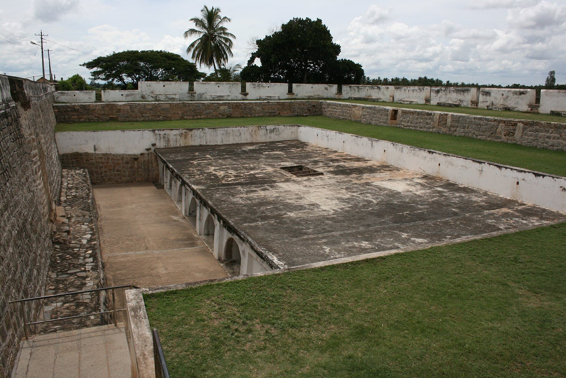 A vaulted stone chamber below ground level with heavy pillars, lit from openings at one end.