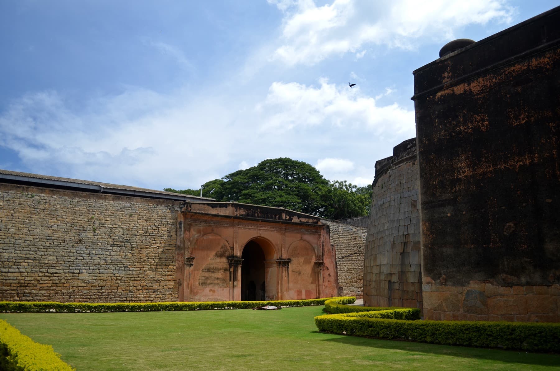 The surviving stone gateway of Bangalore Fort, with heavy masonry walls and a pointed arch.