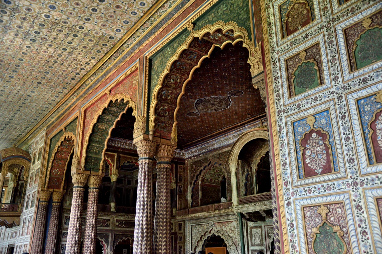Painted floral and foliage scrollwork covering an interior wall and arch of Daria Daulat Bagh.