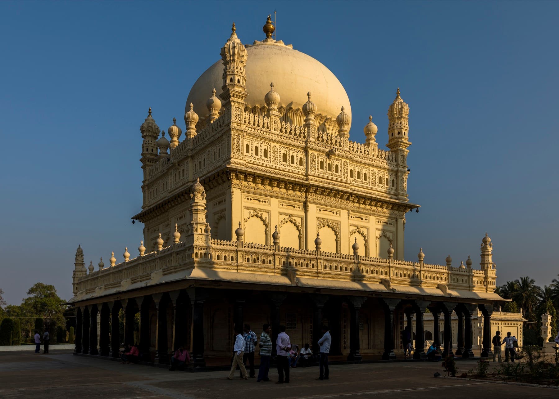 The Gumbaz mausoleum: a domed tomb on a colonnaded plinth of polished black pillars, with slender minarets at the corners.