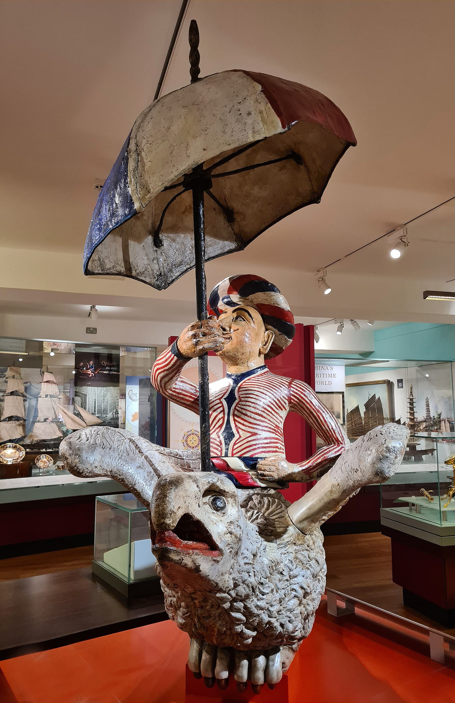 A carved and painted ship's figurehead of a seated turbaned figure.