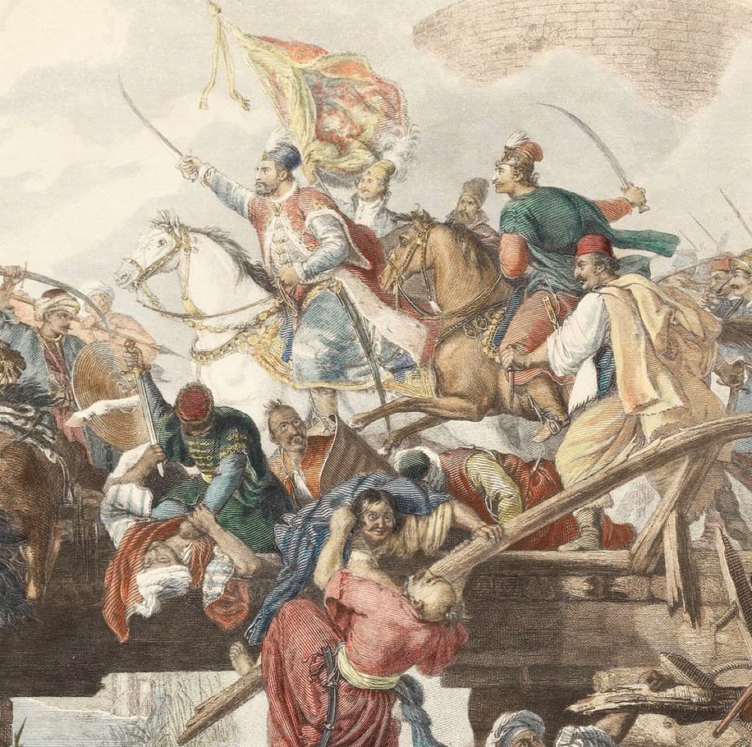 Hand-coloured engraving of a battle at a bridge: a horseman raises his sabre beneath a large banner while cavalry press forward, and wounded men in turbans and fezzes lie among broken timbers in the foreground.